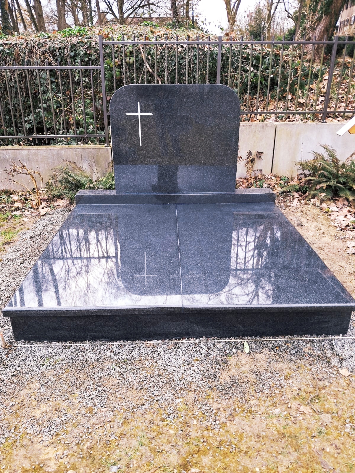 Monument funéraire noir avec croix en doré